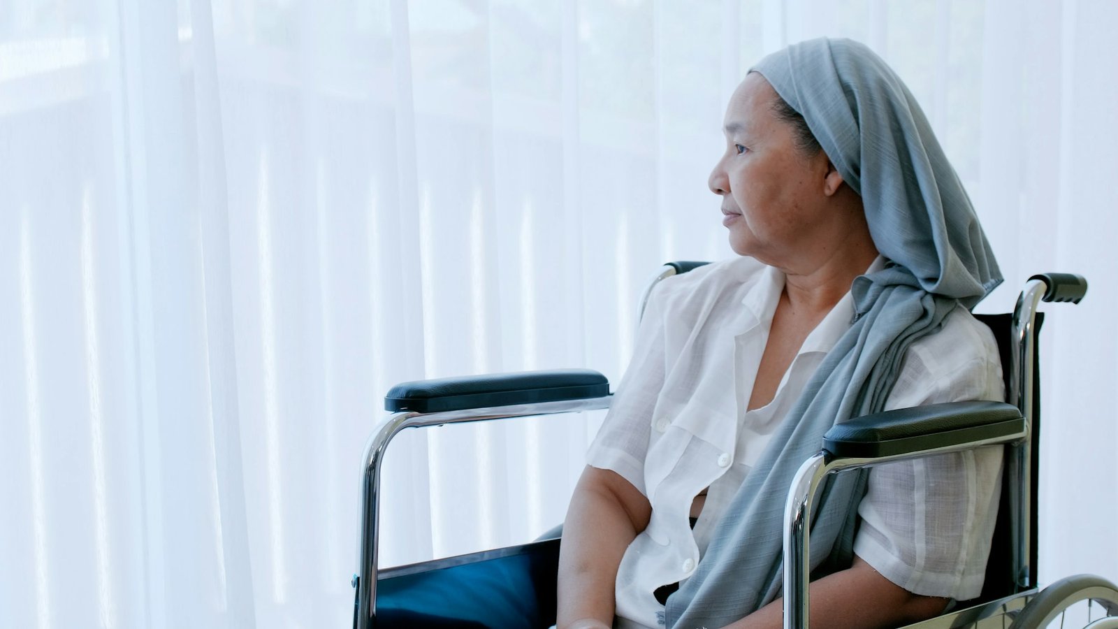 An elderly woman with cancer sitting in a wheelchair